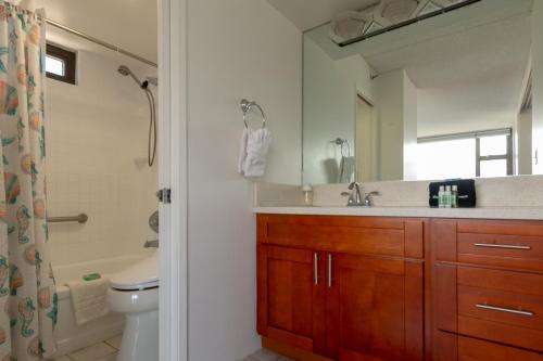 a bathroom with a sink and a toilet and a mirror at Waikiki Banyan Condo with Mountain Views Near Waikiki Beach, Free Parking (22113) in Honolulu