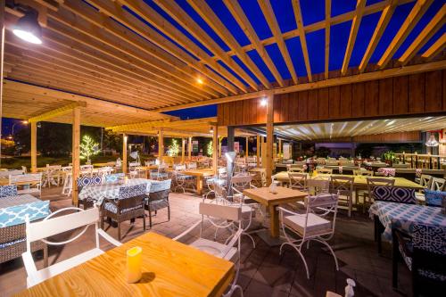 a restaurant with wooden ceilings and tables and chairs at Veja's apartmani in Krk