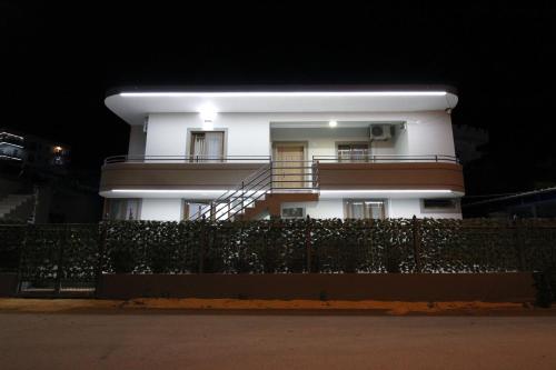a white building with a fence in front of it at Central Villa Shameti in Ksamil