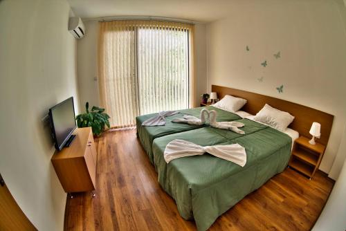 Breste的住宿－Holiday Homes Chudna，一间卧室,配有一张床,床上有一个弓