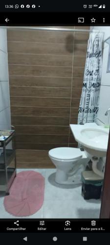 a bathroom with a white toilet and a sink at Chales do Lobão in São Sebastião