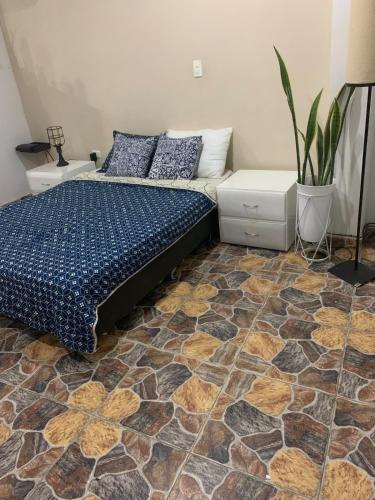 a bedroom with a bed and a floor with tiles at casa hacienda tranquilidad in Estación El Salto