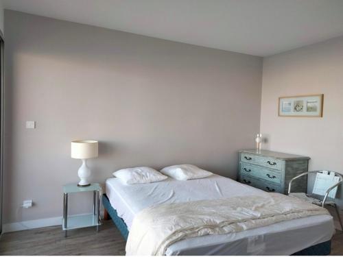 - une chambre avec un lit, une commode et une lampe dans l'établissement T2 tout confort proche plage, 4 pers, ascenseur - FR-1-331-77, à Les Sables-dʼOlonne