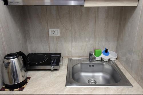 a kitchen counter with a sink and a microwave at Central Villa Shameti in Ksamil