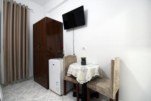a table with two chairs and a television on a wall at Central Villa Shameti in Ksamil