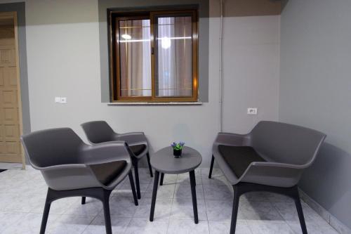 a room with three chairs and a table and a window at Central Villa Shameti in Ksamil
