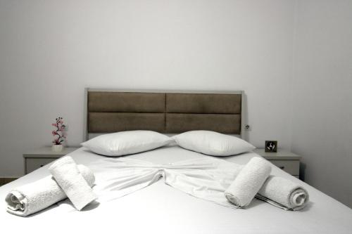 a white bed with two pillows on top of it at Central Villa Shameti in Ksamil