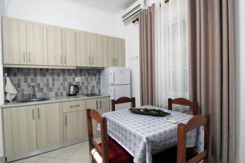 a kitchen with a table and a sink and a refrigerator at Central Villa Shameti in Ksamil