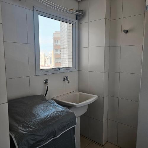 a bathroom with a sink and a window at Requinte e sofisticação in Praia Grande
