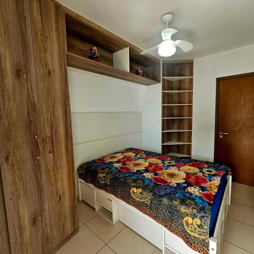 a bedroom with a bed with a colorful quilt at Requinte e sofisticação in Praia Grande