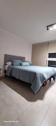 a bedroom with a large bed in a white room at Equipado y hermoso Departamento in Santiago