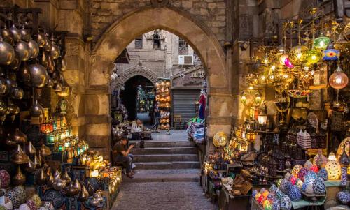 an entrance to a market with a man sitting in the aisle at Exceptional Apartment in the Heart of Historic Cairo, Al-Muizz Street, Downtown in Cairo