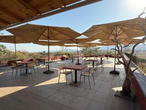 a patio with tables and chairs and umbrellas at El Mesón del Ticúz Tapalpa in Tapalpa