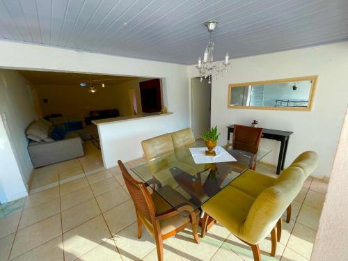 a dining room and living room with a table and chairs at Chácara Refúgio do Vinho in São Roque