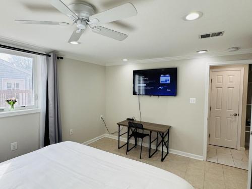 a bedroom with a bed and a table and a ceiling fan at North Bethesda Gem - Entire House 5 min from Metro in Rockville