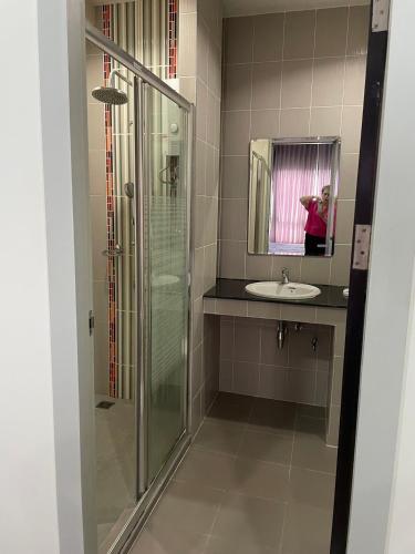 a woman taking a picture of a bathroom with a shower at Vee Condo 502 in Mae Sot