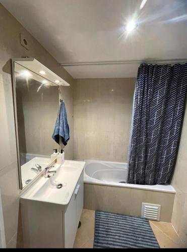 a bathroom with a tub and a sink and a mirror at Applause Oeiras in Oeiras