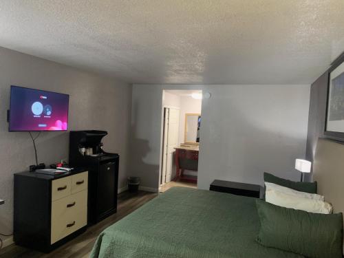a bedroom with a bed and a tv on a dresser at R Nite Star Inn and Suites -Home of the Cowboys & Rangers in Arlington