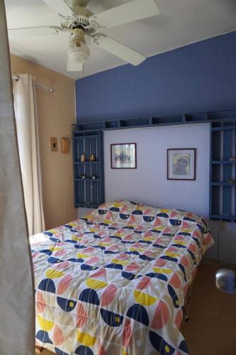 a bedroom with a bed with a colorful quilt at A mini apartment in Cuernavaca, in a good location in Cuernavaca
