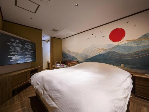 a bedroom with a large white bed and a painting on the wall at HOTEL The KAISER -全室人工ラドン温泉- in Kanie