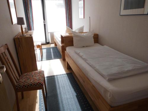 a room with two beds and a chair in it at Germania-46 in Böhl