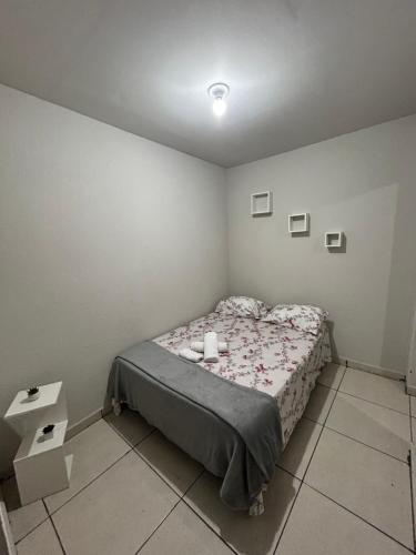 ein kleines Schlafzimmer mit einem Bett und einem Tisch in der Unterkunft Flat Girassol 02 próximo a Graciosa e UFT in Palmas