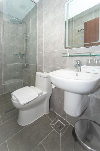 a bathroom with a white toilet and a sink at Bamboo Riverside Boutique Hotel in Ben Tre