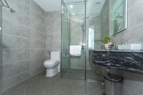 a bathroom with a toilet and a glass shower at Bamboo Riverside Boutique Hotel in Ben Tre