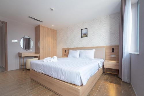 a bedroom with a large bed with white sheets at Bamboo Riverside Boutique Hotel in Ben Tre
