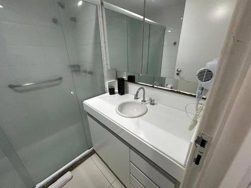 Un baño blanco con lavabo y ducha. en Bela Hospedagem - Imperial Flat - Beira mar de Tambaú, en João Pessoa