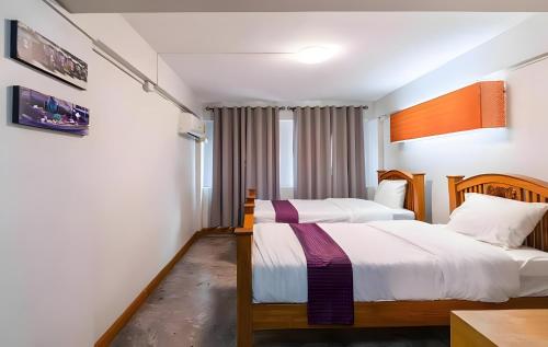 a bedroom with two beds and a table at xx GO INN Khaosan - โกอินน์ ตรอกข้าวสาร in Bangkok
