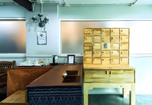 a room with a desk and a wooden cabinet at xx GO INN Khaosan - โกอินน์ ตรอกข้าวสาร in Bangkok