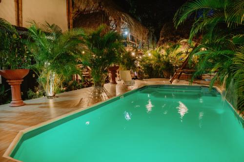 a swimming pool in a yard with palm trees at Kasakolà in Palomino