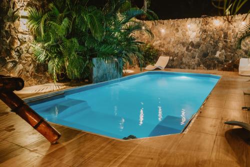 a swimming pool with blue water in a room with plants at Kasakolà in Palomino