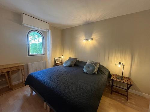 une chambre avec un lit avec des draps bleus et une fenêtre dans l'établissement T2 avec Terrasse et Accès Direct Plage à Arcachon - FR-1-374-228, à Arcachon