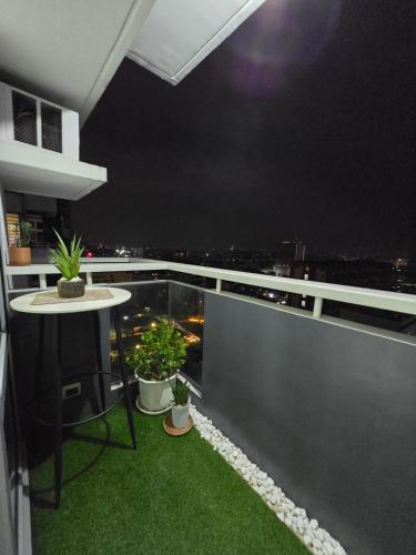 a balcony with a table and potted plants on it at Cozy Corner at Manhattan Heights Tower B 2BR ,2BA Amazing View in Manila