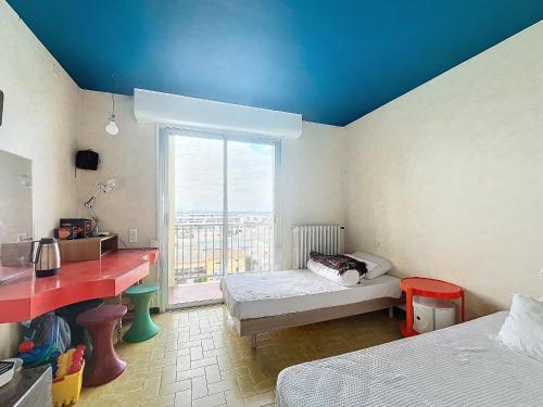 une chambre avec deux lits, un bureau et une fenêtre dans l'établissement Palavas F2 lumineux, proche plage et commerces, TV et wifi inclus - FR-1-715-102, à Palavas-les-Flots