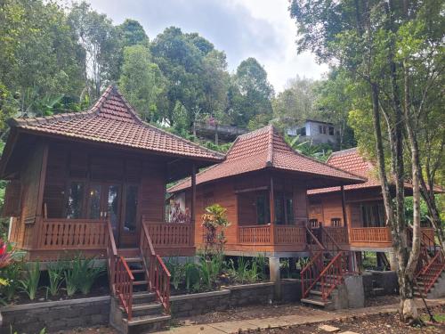 a wooden house with two decks and trees at D'Langun Bali in Munduk