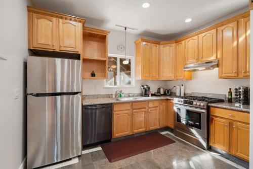 a kitchen with wooden cabinets and a stainless steel refrigerator at Spacious 3BR, One and a half Bath 2nd Floor in San Francisco in San Francisco