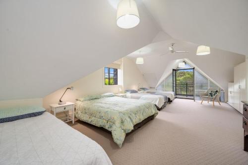Un dormitorio grande con tres camas y una ventana. en Lake House, en Kawana Waters