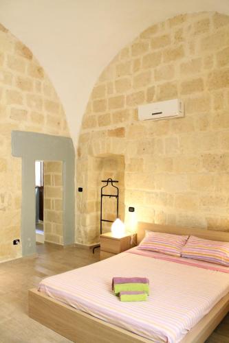 a bedroom with a large bed in a stone wall at Guesthouse A Casina b&b in Trani