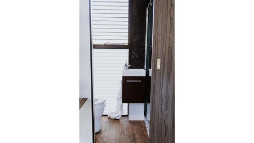a bathroom with a sink and a toilet in a room at Belrose Estate by Tiny Away in Dumbalk