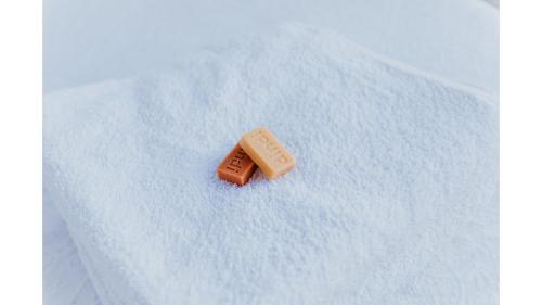 a small chocolate bar sitting on a white blanket at Belrose Estate by Tiny Away in Dumbalk