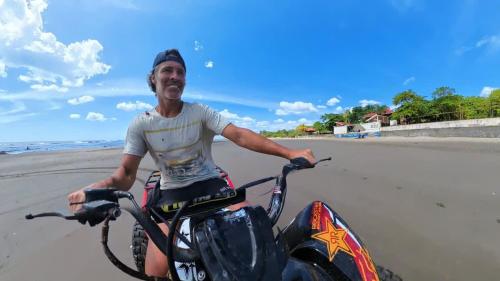 a man sitting on a motorcycle on the beach at 2 Casitas for 8 guests on Beach Front w Pool & AC in Pochomil
