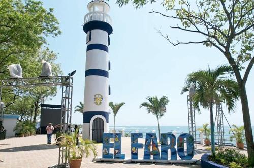 a lighthouse with a sign in front of it at 2 Casitas for 8 guests on Beach Front w Pool & AC in Pochomil