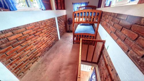 a room with a brick wall and two wooden chairs at 2 Casitas for 8 guests on Beach Front w Pool & AC in Pochomil