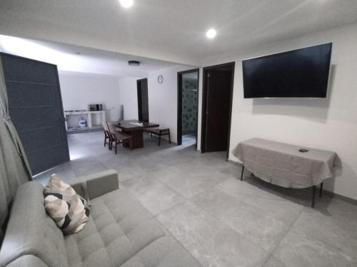 a living room with a couch and a flat screen tv at departamento compartido Aeropuerto-GNP in Mexico City