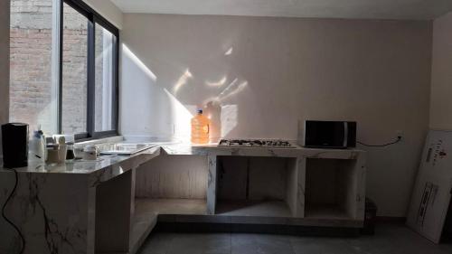 a bottle of orange liquid sitting on a counter in a kitchen at departamento compartido Aeropuerto-GNP in Mexico City