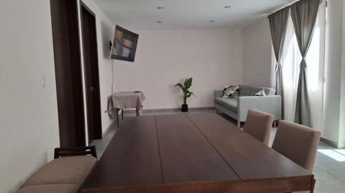 a living room with a wooden table and a couch at departamento compartido Aeropuerto-GNP in Mexico City
