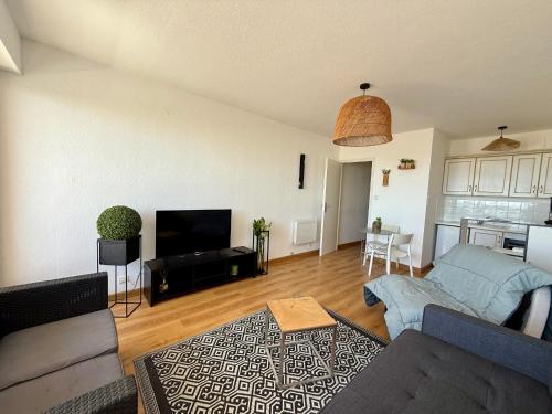un salon avec un canapé et une télévision dans l'établissement Studio à St Jean de Monts, accès plage, 3 pers, balcon - FR-1-652-48, à Saint-Jean-de-Monts